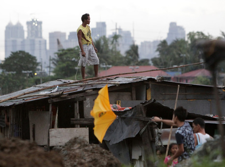 مردی بر بام خانه اش به ویرانی های بجای مانده از طوفان 