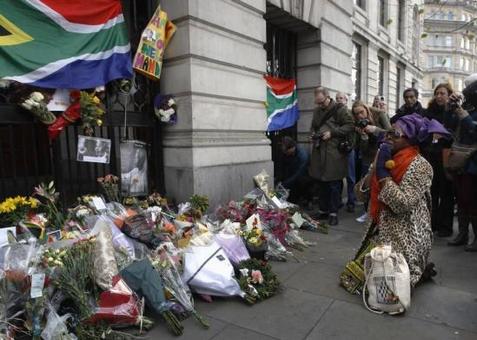 ادای احترام یک زن به «نلسون ماندلا» رئيس جمهور سابق آفریقای جنوبی در کمیسیون عالی آفریقای جنوبی در لندن