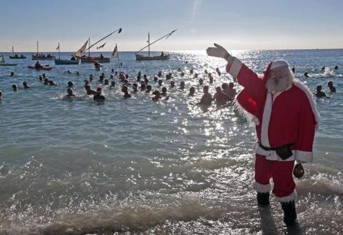 یک مرد با لباس پاپانوئل در ساحل نیس «جایی که حمام‌های سنتی مخصوص کریسمس» در (فرانسه) ایستاده است. مردم فرانسه خود را برای ایام کریسمس آماده می‌کنند. REUTERS/Eric Gaillard
