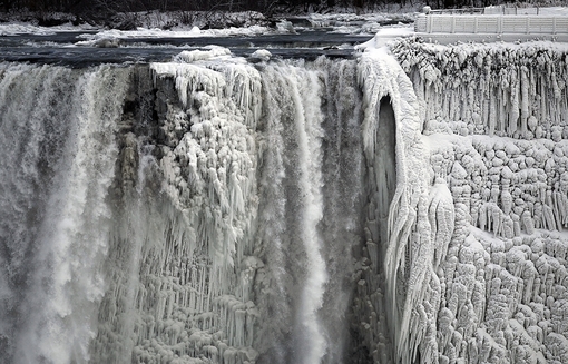 نمایی یخی بخشی از آبشار نیاگارا که در خاک ایالات متحده آمریکا واقع شده از اونتاریوی کانادا به تصویر کشیده شده است. هوای بسیار سردی که نتیجۀ «گردباد قطبی» است و زندگی حدود ۲۴۰ میلیون نفر را در ایالات متحده آمریکا و جنوب کانادا تحت تاثیر قرار داده است از نیمه دوم هفته جاری از این مناطق رخت بر خواهد بستReuters/Aaron Harris