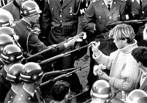 تظاهرکنندگان در سال 21 اکتبر 1967 بعد از راهپیمایی رویداد پنتاگون در اسلحه های نیروهای مسلح گل می‌گذارند