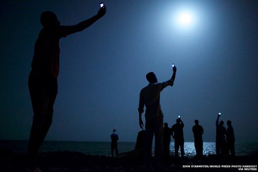 جان استنمیر برنده جایزه امسال مسابقات ورلد پرس فوتو شد. این عکس مهاجران آفریقایی را در ساحل شهر جیبوتی نشان می دهد. آنها می کوشند سیگنال های ارزان قیمت تلفنی را از کشور همسایه،‌ سومالی، دریافت کنند.