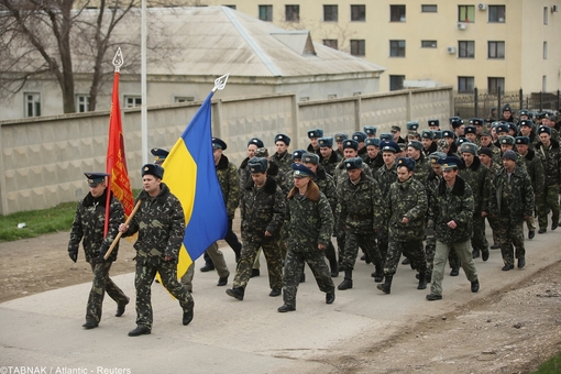 رژه سربازان خلع سلاح شده اوکراینی همراه با پرچم این کشور در منطقه کریمه و در کنار مناطق تحت حفاظت نظامی روسیه
