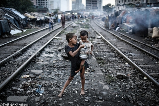 برنده جایزه محیط زیست - عکس از دو کودک میان ریل راه آهن در بنگلادش - آلودگی محیط زیست و تراکم جمعیت فقیران در دو سوی ریلها و پرسپکتیو عالی عکس از ویژگیهای انتخابی این تصویر می باشد