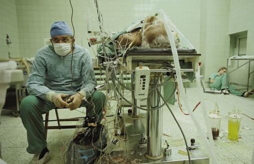 یک جراح پس از عمل 23 ساعته بر روی پیوند قلب بیمارش، علائم حیاتی وی را بررسی می کند.