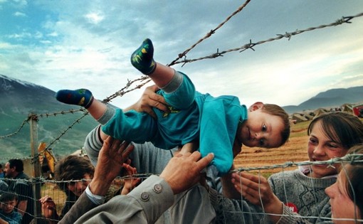 انتقال یک کودک از میان سیم خاردارهای یک اردوگاه، در جریان جنگهای کوزوو