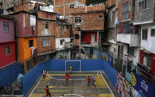 برزیل و فقر در آستانه جام جهانی - جوانان در محله ای فقیر نشین واقع در زاغه تاوارس باستوس در ریو دو ژانیرو مشغول بازی هستند/REUTERS/Pilar Olivares