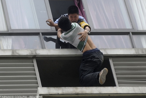 ممانعت پلیس چین از خودکشی یک مرد که قصد دارد خود را از طبقات بالای  ساختمان به پایین پرتاب کند.