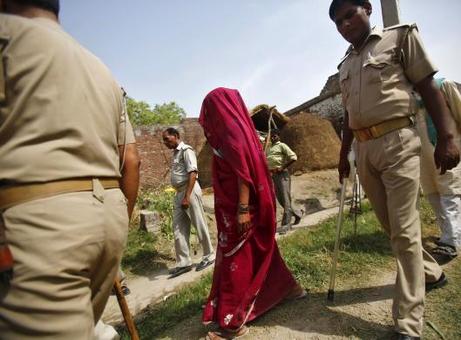 مادر یکی از دو دختر کشته شده در هند همراه با پلیس از محل سکونت خود عبور می کند. موضوع قتل وحشیانه دختران پس از تجاوز به یک موضوعع بزرگ در سطح بین المللی تبدیل شده است. 