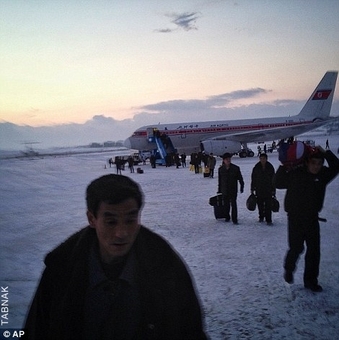 مسافران یک هواپیما بدون امکانات از هواپیمایی که از پکن بازگشته خارج شده و چمدانهای خود را حمل می کنند