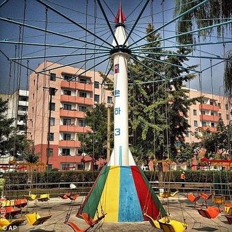 پارک بازی کودکان و ماکت موشک که به تابهای چرخان متصل شده و از نمادهای قدرت کره شمالی