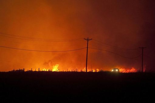 آتش سوزی گسترده در جنگل‌های مرکزی ایالت واشنگتن در شمال غرب آمریکا، باعث صدور هشدار به ساکنان این منطقه برای ترک فوری خانه‌هایشان شد. تصاویر هوایی نشان می دهد: زبانه‌های آتش و دود کماکان از جنگل‌ها و بیشه زارها در نزدیکی منطقه لِون وورت (Leavenworth) در ایالت واشنگتن بر می‌خیزد و در این فصل خشکسالی، روند آتش سوزی در این جنگل‌ها به سرعت به پیش می‌رود. هم‌اکنون روی اکثر خانه‌های روستاهای اطراف آتشسوزی را خاکسترِ جنگل پوشانده است./AP
