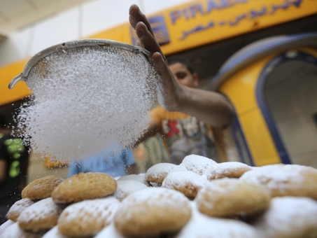 یک کارگر مصری در قاهره شیرینی سنتی«کهک» را می پزد که بخشی از مراسم جشن عید فطر و پایان ماه رمضان است./Reuters 