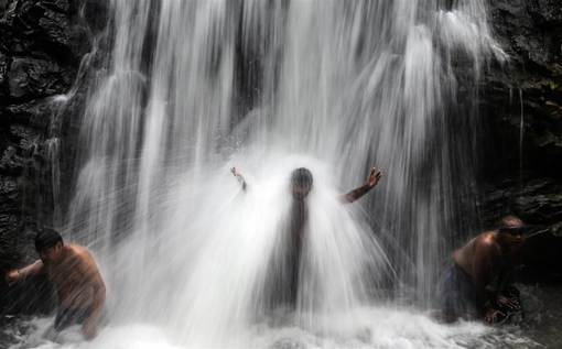 چند مرد هندی زیر آبشار تانگارشوار در حومه بمبئی./EPA 