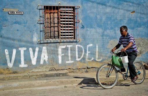یک خیابان در هاوانا و مرد دوچرخه سوار از مقابل اسم فیدل کاسترو ‌می‌گذرد./AFP