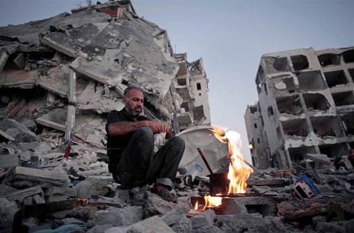 یک شهروند فلسطینی ساکن شهر بیت لاهیا در نوار غزه در کنار ویرانه های محل کسب و کار خود نشسته که در اثر تهاجم گسترده صهیونیستها با خاک یکسان شده است./AP 