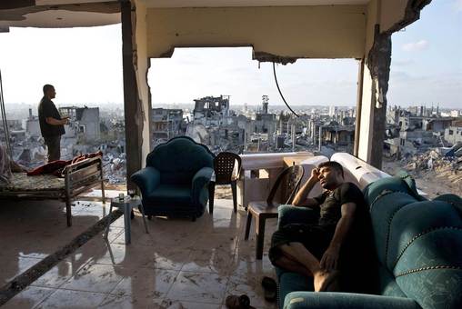 دو شهروند محزون فلسطینی، در ساختمانی واقع در غزه حضور دارند که توسط بمباران رژیم صهیونیستی ویران شده است./ AFP - Getty Images