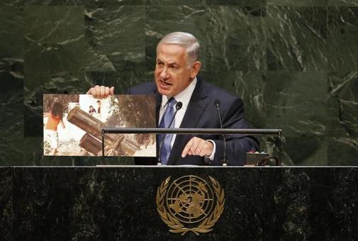بنیامین نتانیاهو با هدف تطهیر سازی ارتش رژیم اسرائیل در جنگ نا برابر علیه فلسطینیان و دفاع از کودک کشی سربازانش در غزه سخنان حیرت انگیزی بیان داشت. وی در سلسله سخنرانیهای مزحکش در سازمان ملل، اینبار مقاومت فلسطین را با تروریستهای تکفیری داعش، النصره و بوکوحرام در یک کفه ترازو قرار داده و سربازان ارتش این رژیم را به عنوان جان بر کفان مبارزه با تروریسم در خط مقدم جنگ در جهان معرفی کرد. در ادامه وی با نمایش یک عکس در هنگام سخنرانی در سازمان ملل، مدعی شد حماس در کنار محل زندگی و بازی کودکان، سکوهای پرتاب موشک مستقر کرده و می کوشد تلفات غیر نظامیان را در جنگ با رژیم صهیونیستی بالا برده تا افکار عمومی جهان را بر علیه صهیونیستها بسیج نماید. بسیاری از منابع خبری معتبر جهان با استهزاء حرکات عجیب نخست وزیر رژیم صهیونیستی، به ادعاهای عجیب وی واکنش نشان دادند./REUTERS 