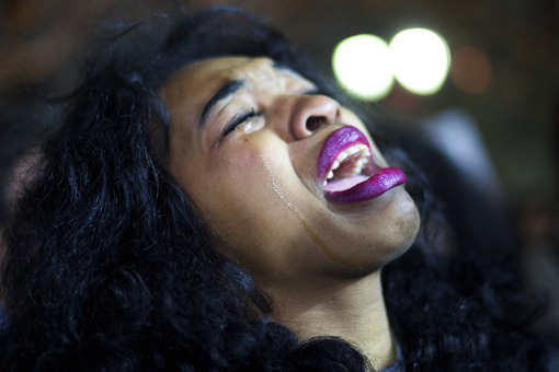 زنی در جریان اعتراضات مردم فیلادلقیا به رأی هیئت منصفه دادگاهی در آمریکا مبنی بر رد اتهام قتل به یک پلیس در جریان کشته شدن یک سیاهپوست در فرگوسن، به شدت گریه می کند./Getty Images

