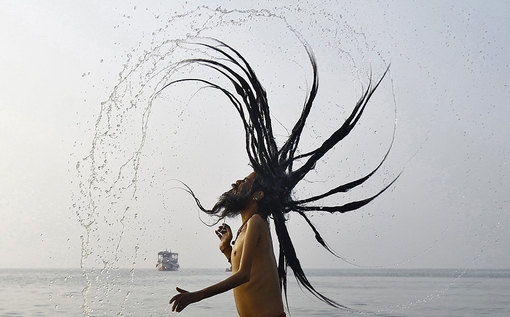 یک مرد مقدس هندی در حال اجرای مراسم شستشوی مقدس در آغاز فستیوال ماکارا سانکرانتی در منطقه ای در جنوب کلکته. این فستیوال از جشنهای برداشت محصول در هند است که به طور سالانه برگزار می شود.
ماکار سانکرانتی یکی از فرخنده ترین روزها برای هندوها است و میلیونها نفر از مردم مکانهایی مانند گنگ ساغر (نقطه ی اتصال رودخانه ی گنگ با خلیج بنگال) غسل می کنند و برای خدای خورشید دعا می خوانند.