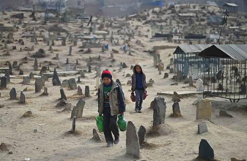 کودکان فروشنده آب در ویرانه های یک قبرستان در افغانستان./AFP - Getty Images<br />
