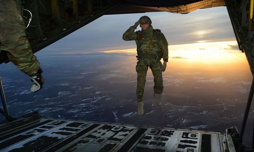 ادای احترام نظامی یک سرباز آمریکایی هنگام پرش از هواپیما هرکول C-130 در جریان یک عملیات آموزشی- تمرینی در آسمان آلمان./U.S. Army
