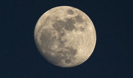 عکس جالب از حرکت هواپیمای مسافربری در آسمان لندن در حالیکه عکاس با نور دهی دوگانه توانسه در زمینه این حرکت تصویری کامل از قرص ماه ارائه دهد!/Getty Images
