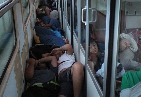 مردمی که به علت کمبود جا در راهروی قطار صربستان خوابیده اند. (EPA)