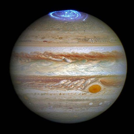 ترکیبی از تصویر ثبت شده از سیاره مشتری توسط تلسکوپ فضایی هابل در بهار 2014 و شفق‌های قطبی آن در نورفرابنفش در سال 2016
