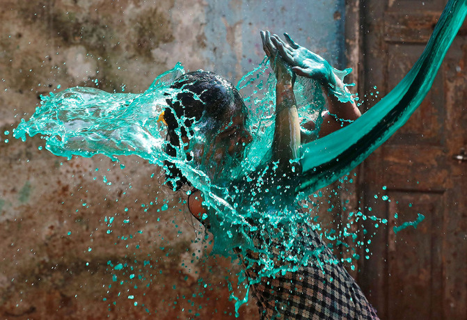 دختری در بمئی هند در جشنواره رنگ ها؛زیر موجی از آب های رنگین