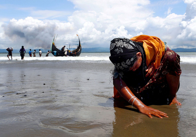 یک زن خسته روهینگیایی در سواحل بنگلادش بر ساحل نشسته است. او با قایق از مرز میانمار و بنگلادش عبور کرده و چنین خسته به بنگلادش رسیده است. تا کنو بیش از 600 هزار بنگلادشی از ترس جان به بنگلادش گریخته اند.