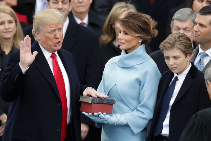 دونالد ترامپ رئیس جمهور آمریکا بر انجیلی که در دستتان همسرش ملینیا است،سوگند می خورد؛پسر کوچک او هم نظاره گر این صحنه اس.