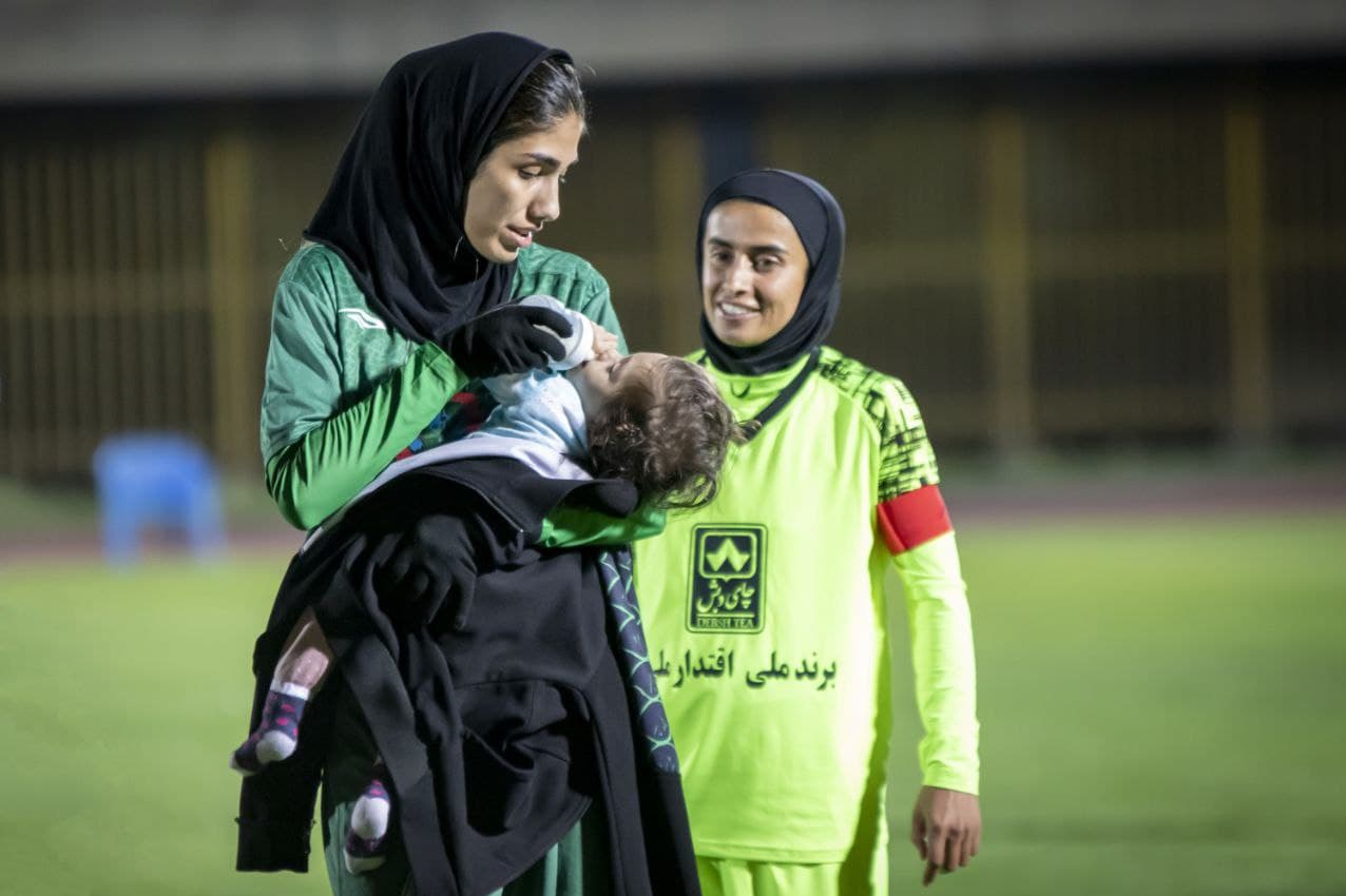                                                    شیردادن مادر به فرزندش وسط زمین فوتبال                                       