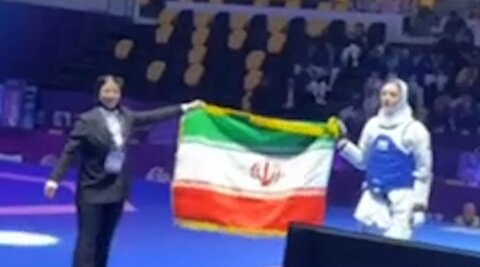 دور افتخار و سلام نظامی حنا زرین‌کمر با پرچم ایران