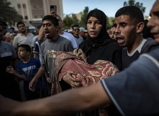 خان یونس، غزه یک زن جسد فرزندش را که در حمله هوایی به خانه ای در اردوگاه پناهندگان خان یونس شهید شده، حمل می کند.