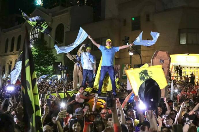 بوینس آیرس، آرژانتین
طرفداران خاویر مایلی پیروزی او در دور دوم انتخابات ریاست جمهوری را بیرون از مقر حزب جشن می گیرند. 