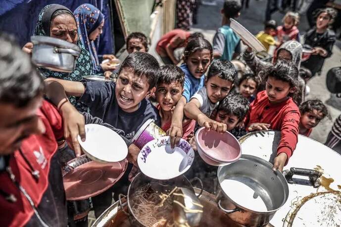 خان یونس، غزه ـ کودکان برای دریافت غذای توزیع شده توسط خیریه ها صف می کشند.