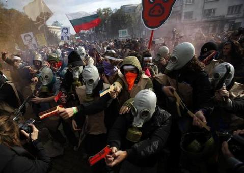  دانشجویان معترض با پوشیدن ماسک&zwnj;های ضد گاز و حامل اسلحه جعلی ساخته شده از مقوا؛ تظاهرات در جلوی پارلمان در صوفیه 