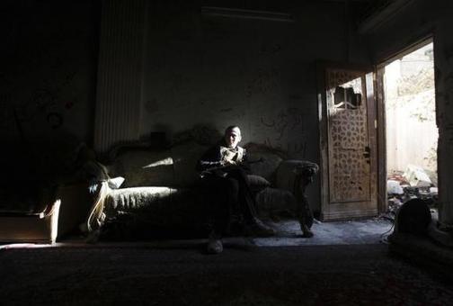 جنگجوی ارتش آزاد سوریه مصمم روی یک مبل در شرق سوریه