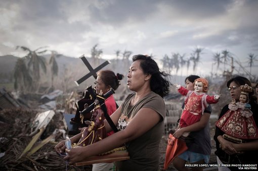 نجات یافتگان توفان هایان در مراسمی مذهبی در تولوسای فیلیپین. این عکس برنده جایزه اول در یکی از رشته های تک عکس خبری شده است.