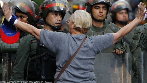 یکی از مخالفان دولت مادورا(ونزوئلا)، در مقابل پلیس ضد شورش ایستاده 