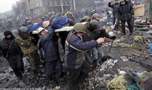 معترضان ضد دولتی اوکراین در حال حمل یک مرد مجروح با برانکارد در میدان استقلال 