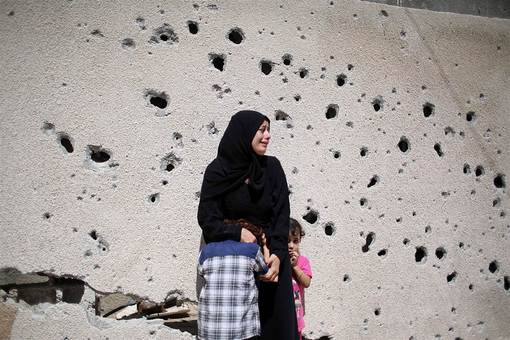شهروند فلسطینی ساکن خان یونس در جنوب نوار غزه، کنار دیوار در حزن شهادت دو نوجوان ۱۲ و ۱۶ ساله فلسطینی که در آخرین روز تهاجم صهیونیست‌ها به شهادت رسیده‌اند می‌گرید. /AFP - Getty Images