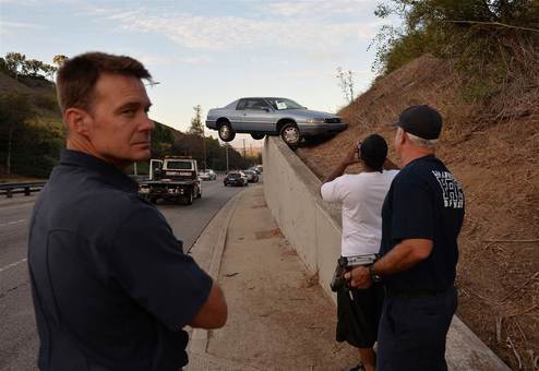 شهر لس آنجلس و صحنه جالب از عدم کنترل خودرو توسط راننده که ماشین را به پایین جاده منتقل کرده و خوشبختانه در میان دیوار حائل بتنی گیر افتاده و از یک حادثه تلخ جلوگیری شده./AFP - Getty Images
