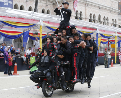 31 lمرد و زن سوار بر موتور و حفظ تعادل جالب این وسیله توسط هنرمندان مالزیایی در حاشیه جشن روز استقلال در کوالالامپور /Reuters