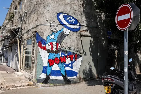 تل آویو، اسرائیل ـ نقاشی دیواری گروه هنری Grafitiyul که جو بایدن را در نقش شخصیت کمیک مارول کاپیتان آمریکا با پرچم اسرائیل و سپر ستاره دیوید به تصویر می&zwnj;کشد.