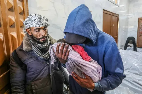 خان یونس، غزه ـ بستگان جسد یک نوزاد شهید در حملات اسرائیل را به سردخانه بیمارستان اروپایی منتقل کردند.