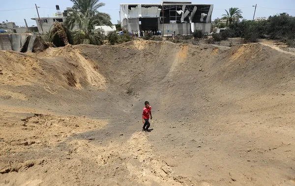 حرکت یک جوان فلسطینی از محل انفجار راکت اصابت کرده در حمله هوایی رژیم صهیونیستی به غزه /AP
