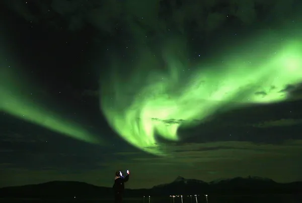 یک گردشگر در حال عکسبرداری از پدیده &zwnj; شفق قطبی در نزدیکی قطب شمال است. شفق قطبی یکی از پدیده&zwnj;هایی است که معمولا در نزدیکی دو قطب شمال و جنوب قابل رویت است. این پدیده معمولا در بهار در ماه&zwnj;های مارس و آوریل و در پاییز در ماه های سپتامبر و اکتبر روی می&zwnj;دهد. /Reuters- Euronews
