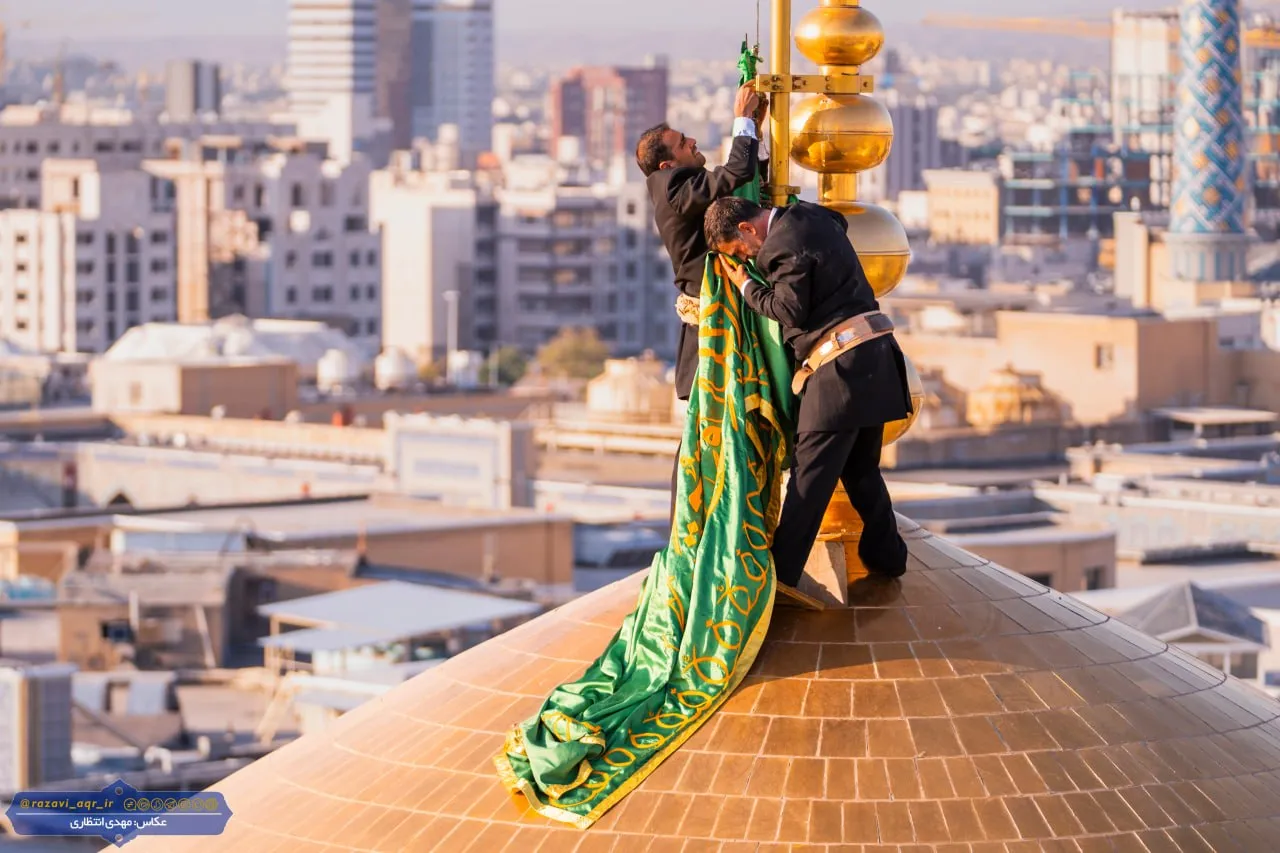 تعویض پرچم گنبد مطهر امام رضا (ع) بعد از ۶٣ روز
